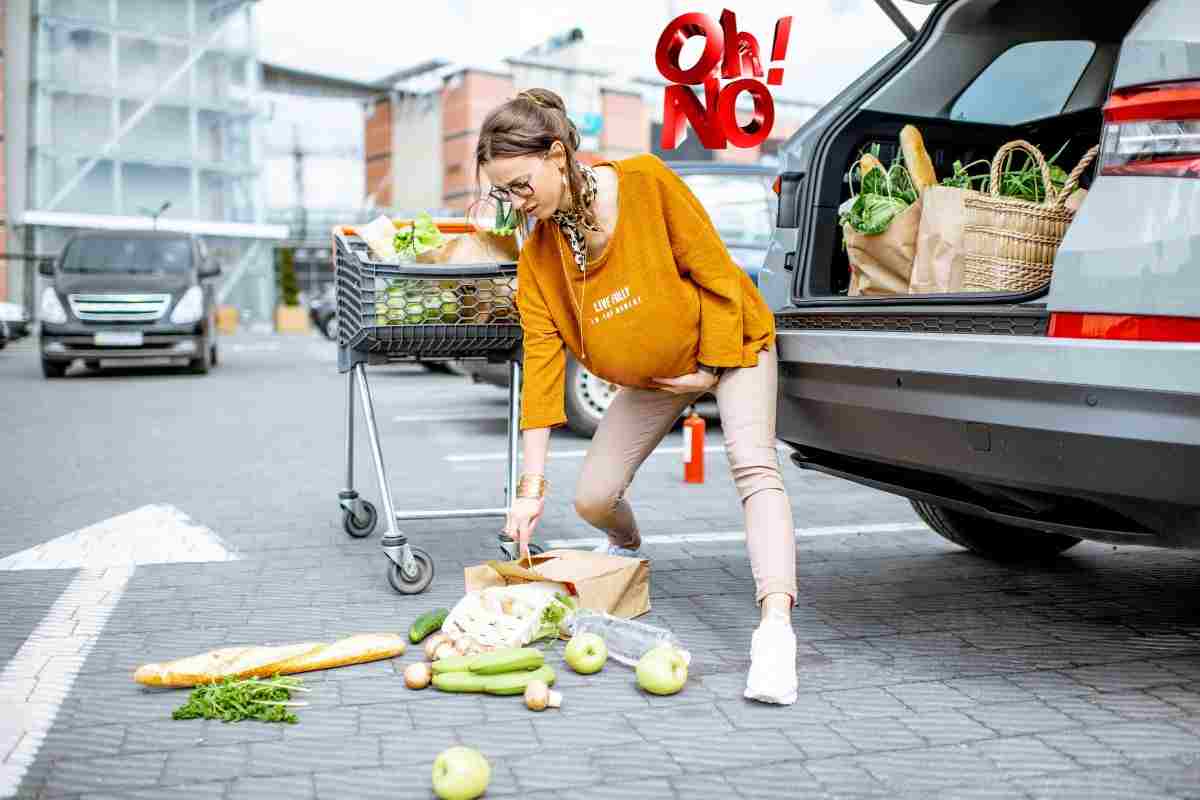 Donna incinta con spesa caduta a terra