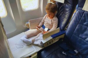 una bambina gioca seduta sul sedile di un aereo